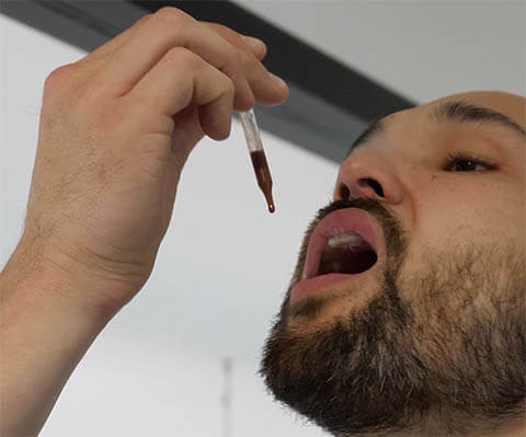 A man holds deer antler velvet drops under his tongue. Learn why